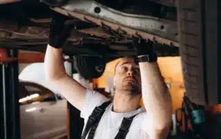 Mechanic inspecting a European luxury car in a professional auto repair shop, debunking common repair myths.
