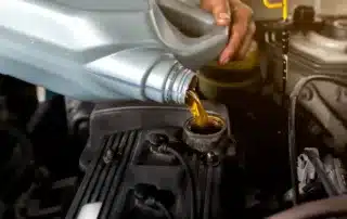 Mechanic performing a winter car checkup, including an oil change and engine tune-up, at Carage in Jupiter, FL.