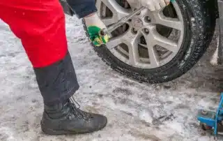 Mechanic performing a winter car maintenance check, including an oil change and battery inspection, at Carage in Jupiter, FL.