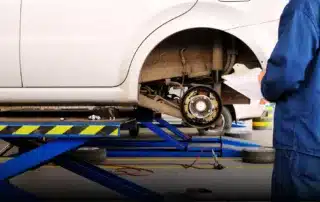 Carage Auto technician repairing vehicle brakes inside a full-service auto repair shop.
