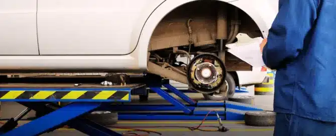 Carage Auto technician repairing vehicle brakes inside a full-service auto repair shop.