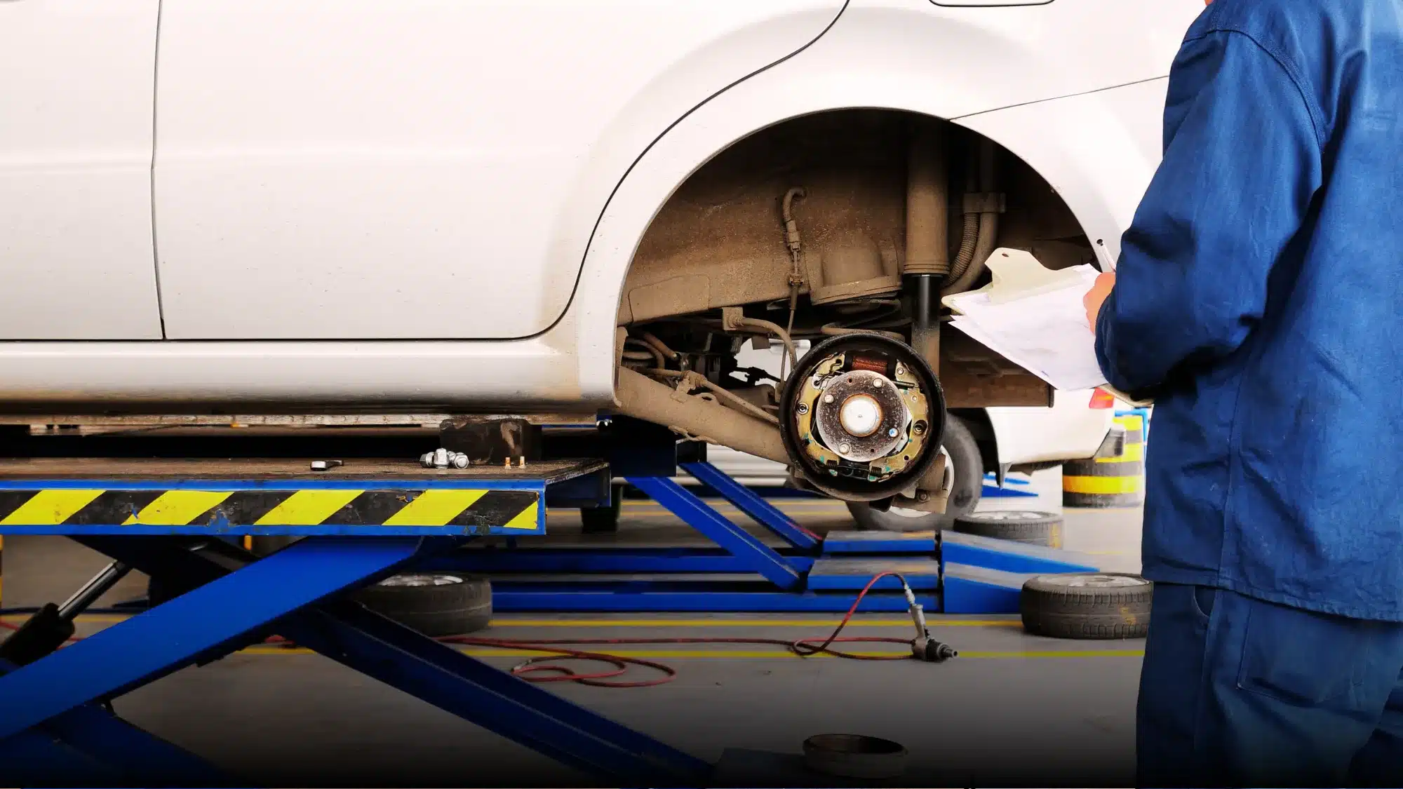 Carage Auto technician repairing vehicle brakes inside a full-service auto repair shop.