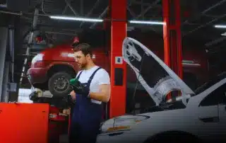 Top-rated mechanic at Carage Auto inspecting a car engine inside a clean, professional auto repair shop.