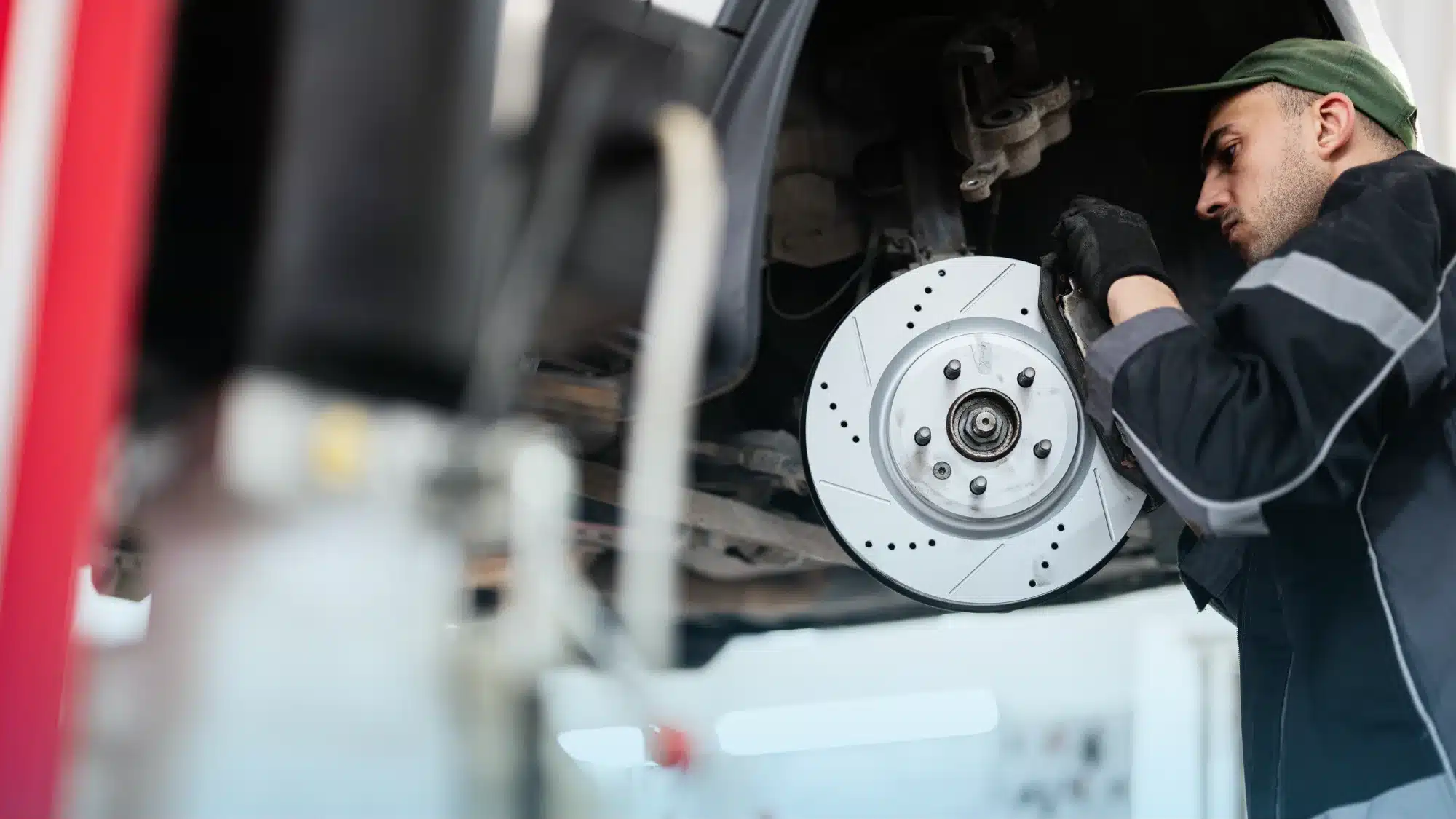 Mechanic performing brake repair on car in auto shop