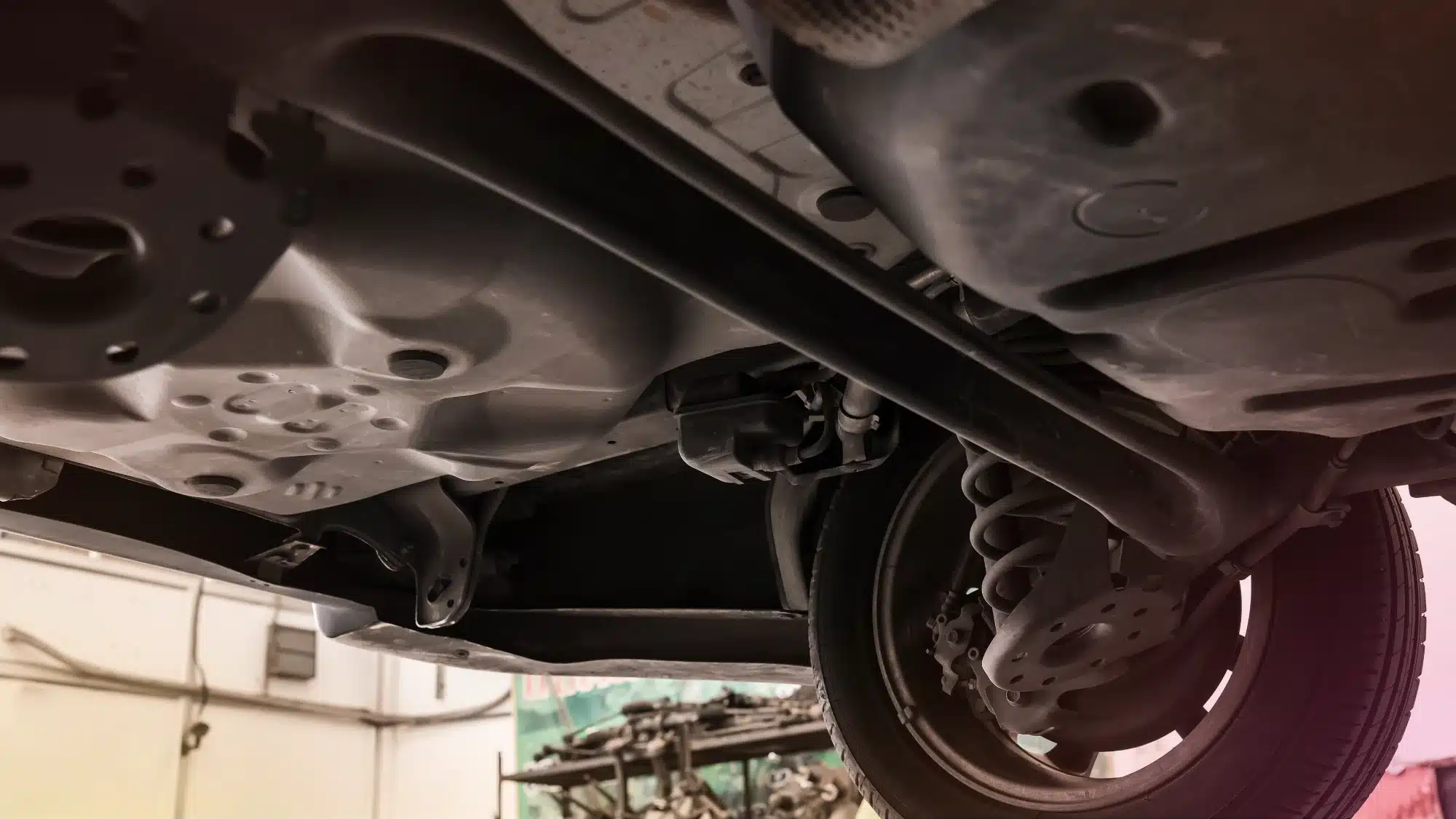 Auto technician inspecting a vehicle suspension system to identify early signs of wear and alignment problems