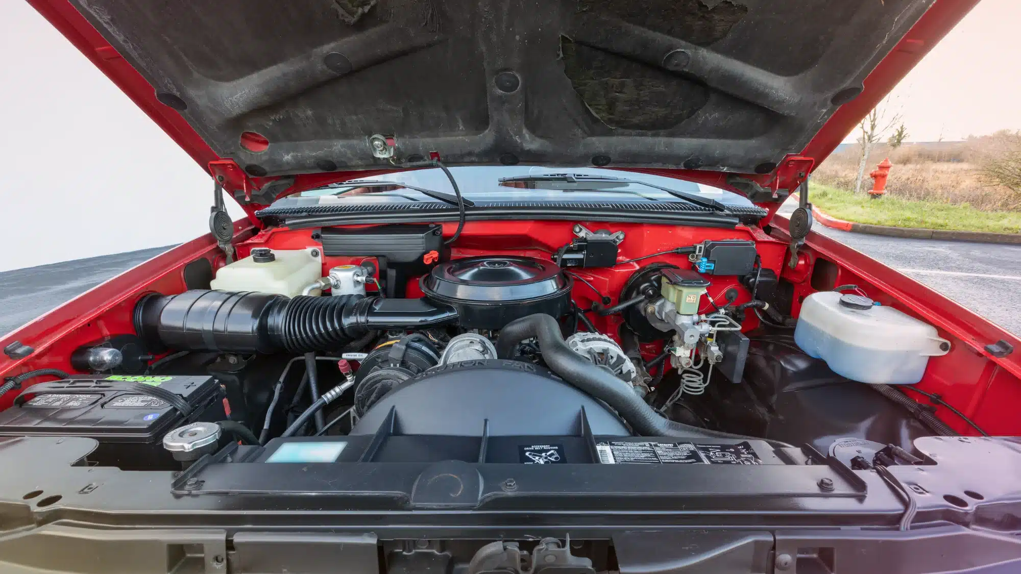 Certified Chevrolet technician performing diagnostics and maintenance on a Chevy vehicle inside a professional auto repair shop