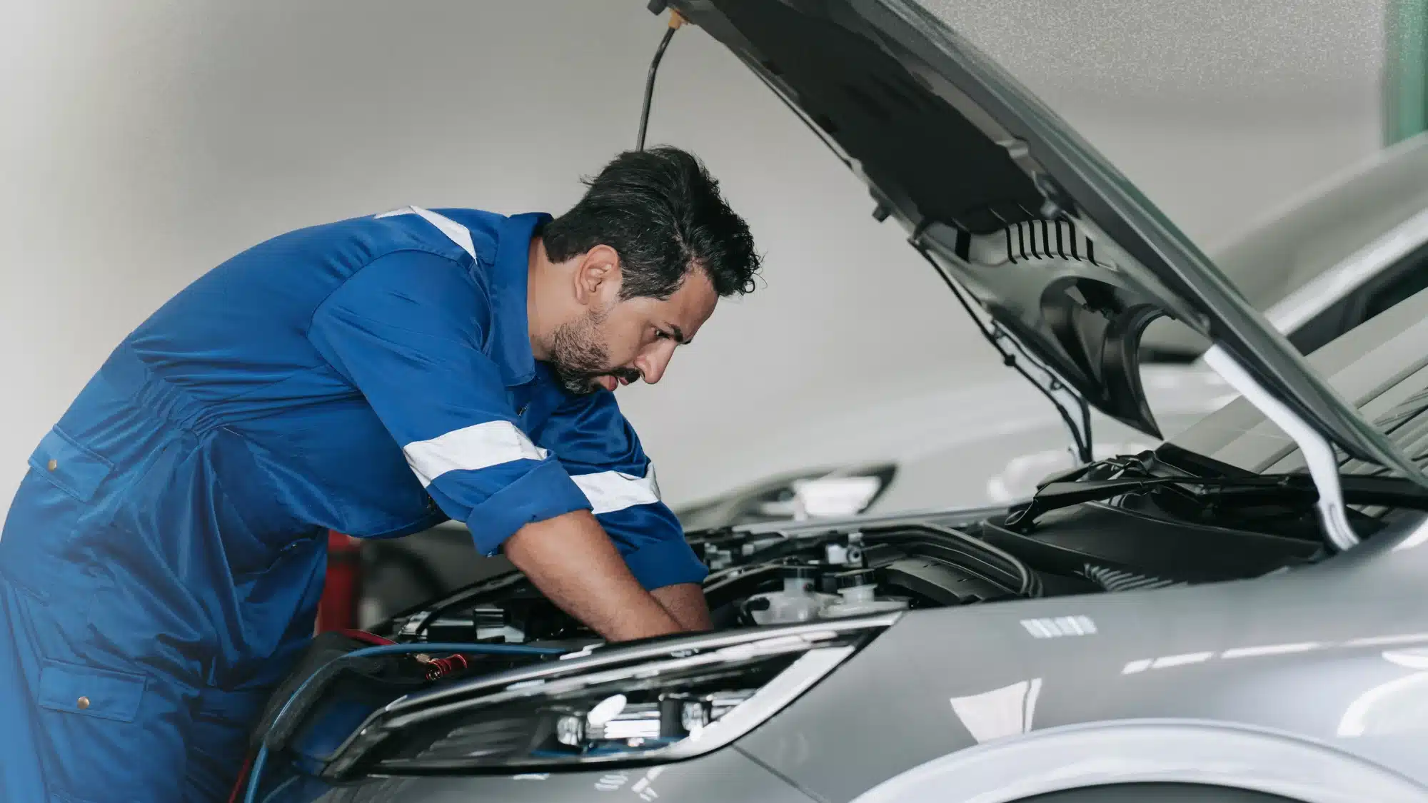 Qualified mechanic performing hybrid car repair at a shop in Jupiter FL